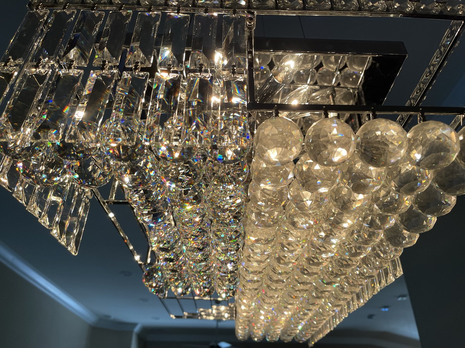 Crystal chandelier mid-cleaning, finished side sparkling beside the untouched side
