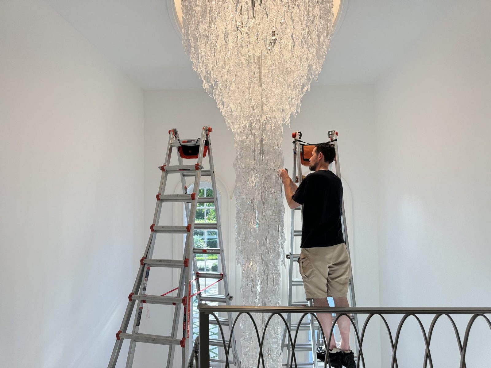 Brightmen technician hand-cleaning a crystal chandelier