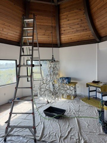 Ladder and floor protection staged for a chandelier removal