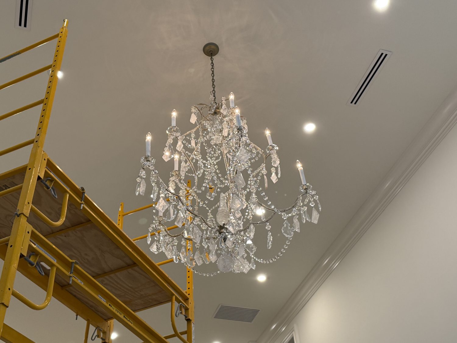 Rock-crystal chandelier accessed by scaffold for removal