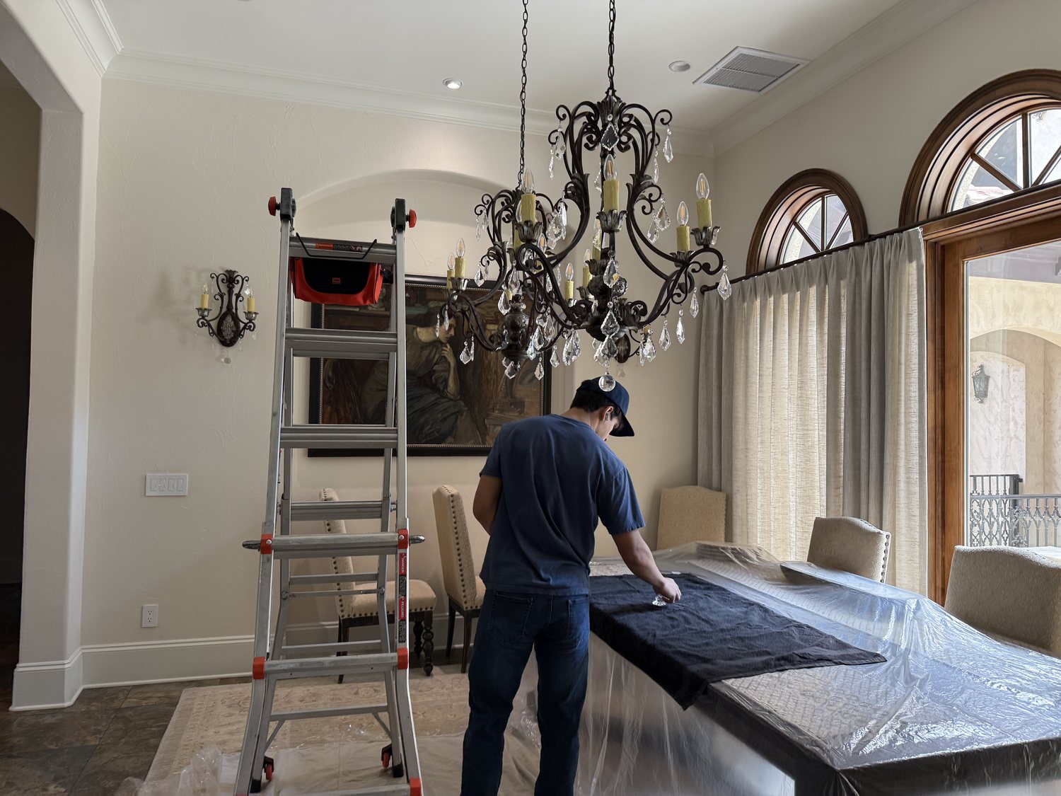 A Brightmen technician cleaning a chandelier
